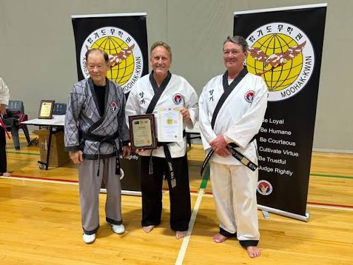 Grandmaster John Gill receiving a certificate from his Korean Grandmaster at a Moo Hak Kwan grading